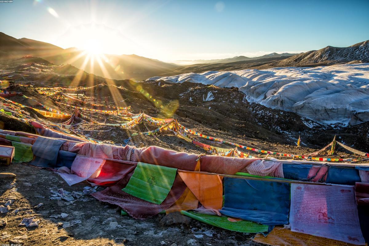 The snow-capped mountains and colorful prayer flags on the western Sichuan plateau shine together under the morning sun